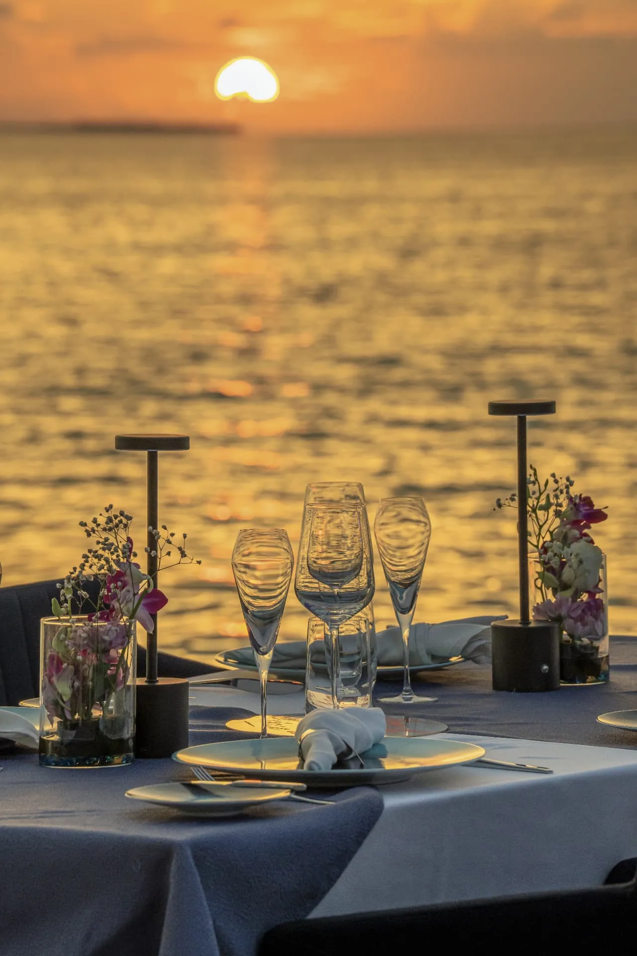 Table dressée face au coucher de soleil sur l’océan